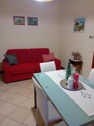 sala de estar con mesa y sofá rojo en Casa rosa en Arezzo