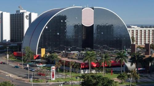 a large curved building in a city with buildings at Flat no coração de brasília in Brasilia