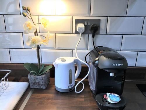 une cafetière et une cafetière sur un comptoir dans l'établissement Newly Refurb Period 1-Bed Apartment with Roof Terrace, 47 sqm-500 sqft, in Putney near River Thames, à Londres