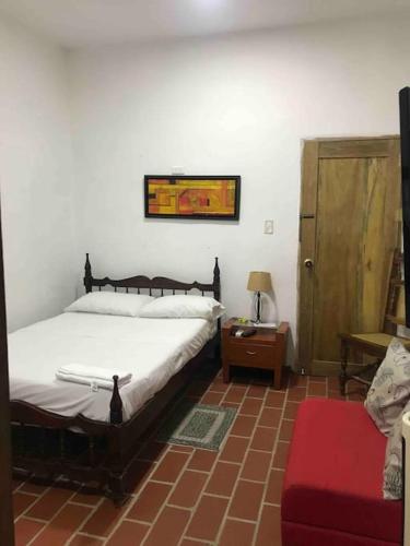 a bedroom with a bed and a table and a door at Apartamento Concepción Mompox in Mompós