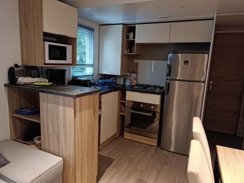 a kitchen with a stainless steel refrigerator and a stove at mobil home 3 chambres 152 in Pont-Aven