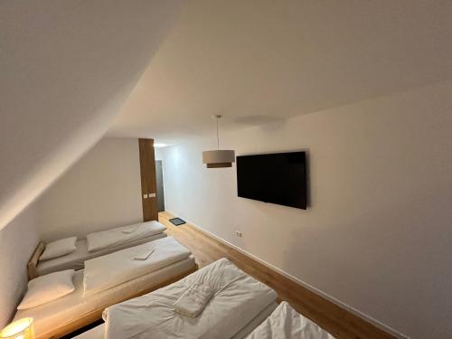 a room with two beds and a flat screen tv at Jamy House in Habovka