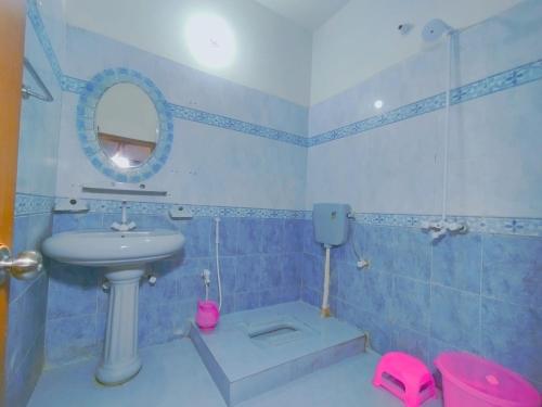 a blue bathroom with a sink and a mirror at Jinnah Airport Hotel in Karachi