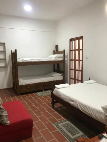 a room with two bunk beds and a red couch at Apartamento Concepción Mompox in Mompós