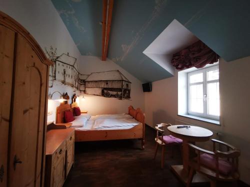 a bedroom with a bed and a table and a window at Machlandgasthof Wahl in Ruprechtshofen