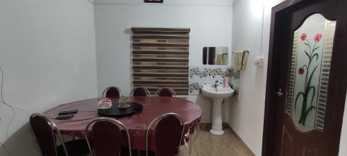 uma sala de jantar com uma mesa e cadeiras e um lavatório em Koonamparayil Home Stay Munnar Anaviratty-Family Only em Anaviratty