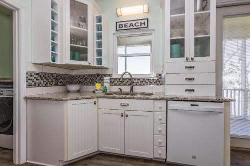 Una cocina con gabinetes blancos y un fregadero. en Hideaway Bay, en Gulf Highlands