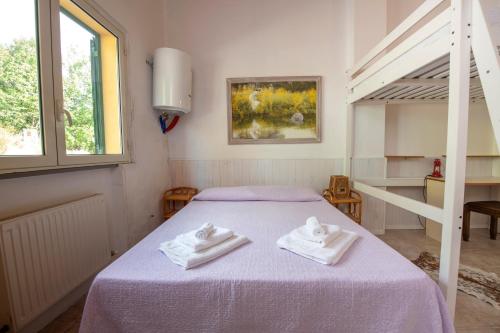 um quarto com uma cama com duas toalhas em 210 - Appartamento Larice - Terrazza, giardino e piscina em Carro