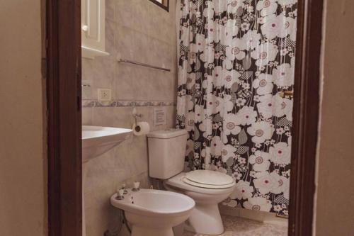 een badkamer met een toilet, een wastafel en een douchegordijn bij Apart Vitraux in Las Gaviotas