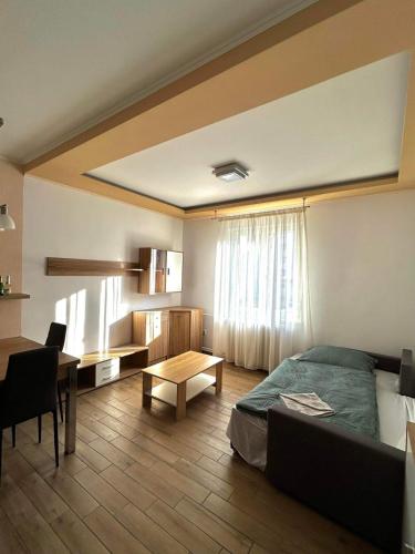 a bedroom with a bed and a table and a desk at Wiener Garden 40 in Győr