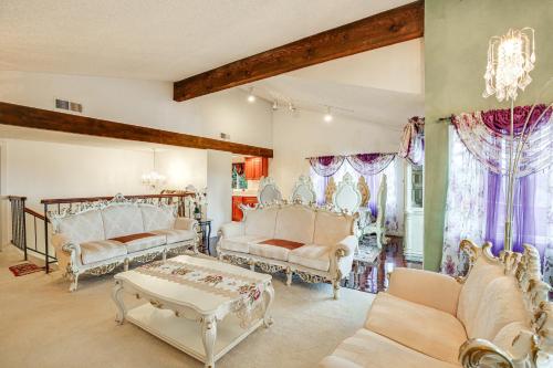 una sala de estar con muebles blancos y una lámpara de araña. en Family-Friendly San Pedro Home 3 Mi to Beach!, en San Pedro