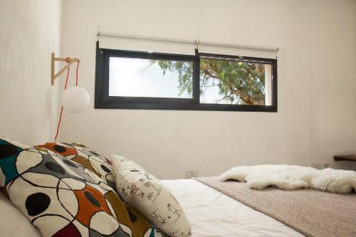 1 dormitorio con 1 cama y ventana en lo de Ernesto en Villa Carlos Paz