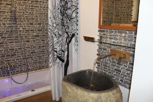 a bathroom with a tub with a water fountain at Ferienhaus Waldidyll in Langfurth 