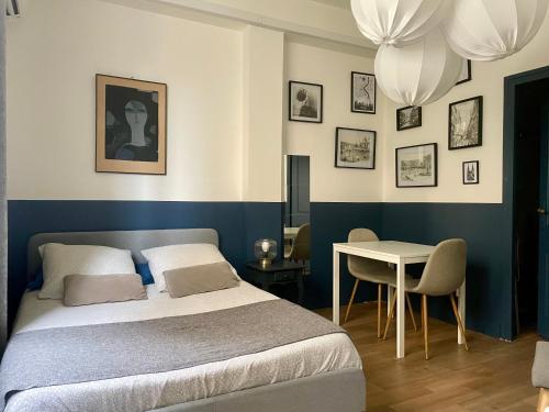 - une chambre avec un lit, une table et des lustres dans l'établissement Les Appartements à Gambetta, à Bordeaux
