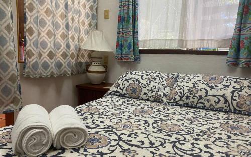 a bedroom with a bed with towels on it at The Octopus's Garden Hostel in Cruz de Huanacaxtle