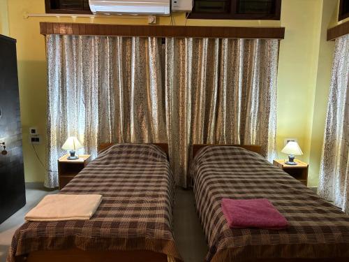 two beds sitting next to each other in a room at Nivriti (Bliss) Homestay in Guwahati