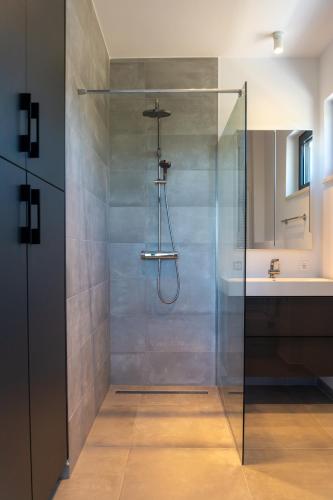 a shower with a glass door in a bathroom at Korala - Luxe villa met 4 dubbele kamers en privé zwembad in Vinišće