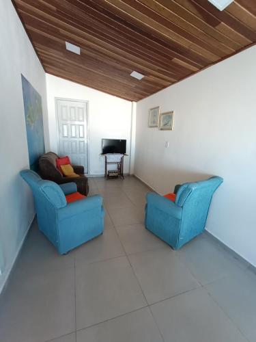 ein Wohnzimmer mit 2 Stühlen und einem TV in der Unterkunft Casa Pé na Arreia in Arroio do Silva