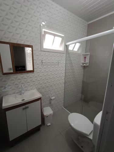 ein Bad mit einem WC, einem Waschbecken und einer Dusche in der Unterkunft Casa Pé na Arreia in Arroio do Silva