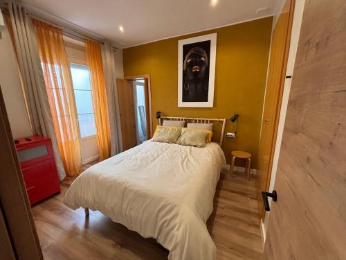 PRECIOUS AND ORIGINAL APARTMENT CENTER في كاديز: غرفة نوم بسرير في جدار اصفر