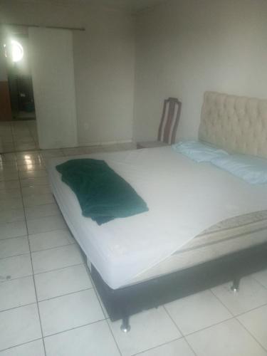 Una cama en una habitación con una almohada verde. en Casa da piscina en Río de Janeiro