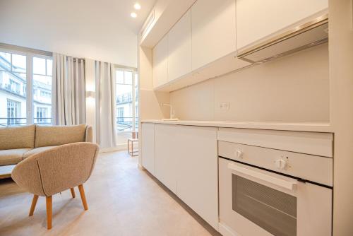 - une cuisine avec un canapé et une chaise dans la chambre dans l'établissement Amazing flat - CHAMPS ELYSEES, à Paris