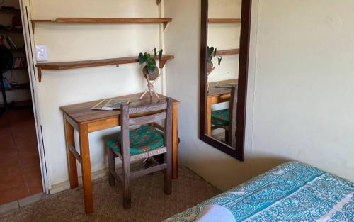 a table with a chair and a mirror in a room at The Octopus's Garden Hostel in Cruz de Huanacaxtle
