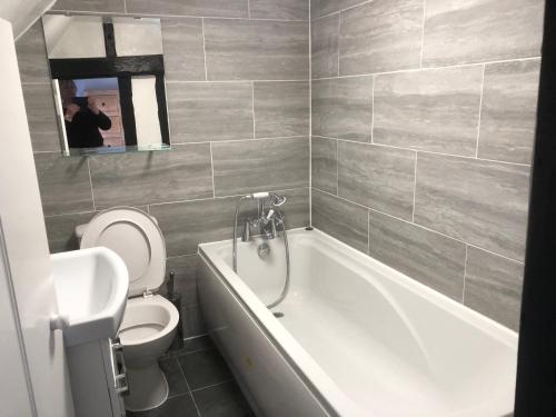 a bathroom with a tub and a toilet and a sink at The Star in Lydd