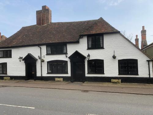 a white building with black doors on a street at The Star in Lydd