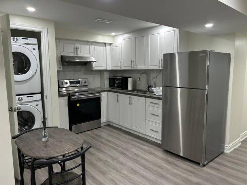 a kitchen with white cabinets and a stainless steel refrigerator at 2 Bedroom private apartment with private entrance in Brampton