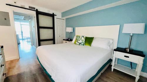 a bedroom with a white bed and a blue wall at Sea Watch Resort in Myrtle Beach