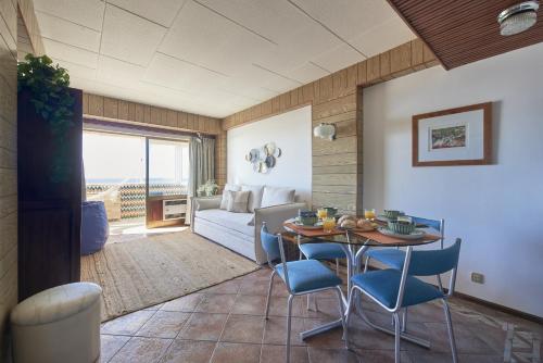 a living room with a table and chairs and a bedroom at Stunning Beach Sunset View, By TimeCooler in Costa da Caparica