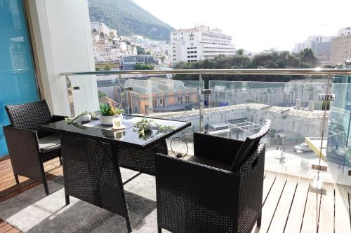 balcón con mesa, sillas y vistas en Gibraltar Luxury with Rooftop Pools & Views en Gibraltar