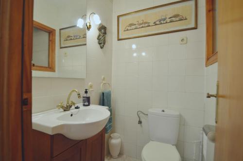 ein weißes Bad mit einem Waschbecken und einem WC in der Unterkunft La Pla House in El Campello