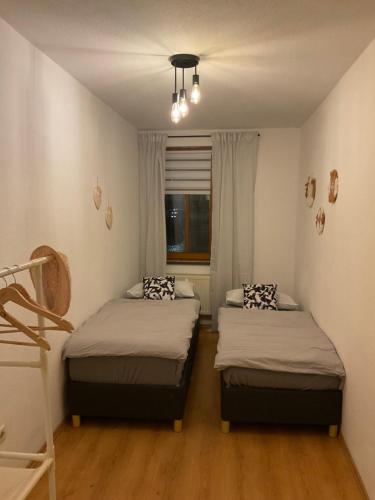two beds in a small room with a window at Ferienwohnung am Markt in Kirchberg