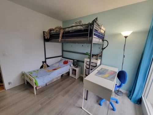 ein kleines Schlafzimmer mit einem Etagenbett und einem Schreibtisch in der Unterkunft JO 2024 -Appartement familial tout confort in Guyancourt