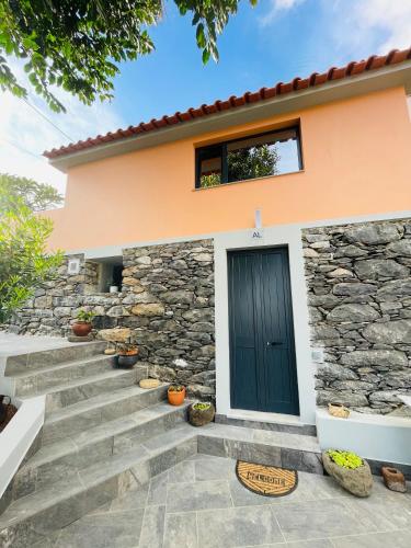 a house with a black door and stairs at Cozy House in Funchal