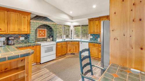 Una cocina con gabinetes de madera y refrigerador. en Quelah Lane - Unit 10, en Sunriver