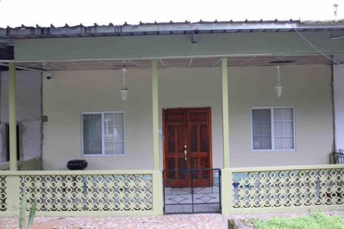 uma casa com uma porta vermelha e uma varanda em Casa LUNA em Boquete