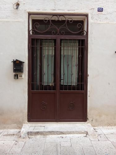 eine braune Tür mit einem eisernen Tor auf einem Gebäude in der Unterkunft CASA NEL QUARTIERE DELLE CERAMICHE in Grottaglie