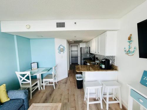 a living room and kitchen with a couch and a table at Sea Watch Resort in Myrtle Beach