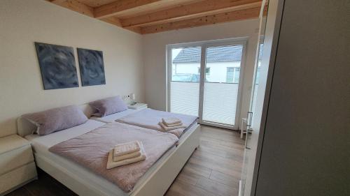 a bedroom with a bed and a large window at Ferienhäuser Prüm in Prüm