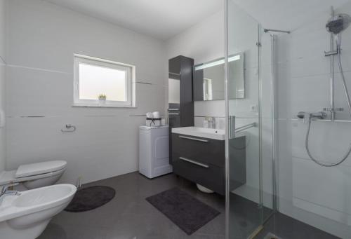 een badkamer met een toilet, een wastafel en een douche bij Residence David in Poreč