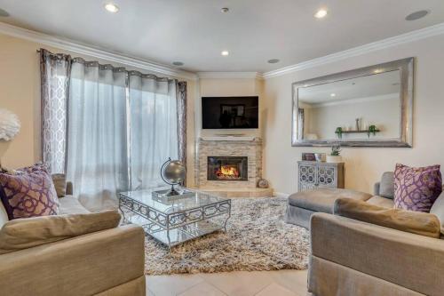 a living room with a couch and a fireplace at 4BR Spectacular Harbor View Modern Home 5min Zoo in San Diego