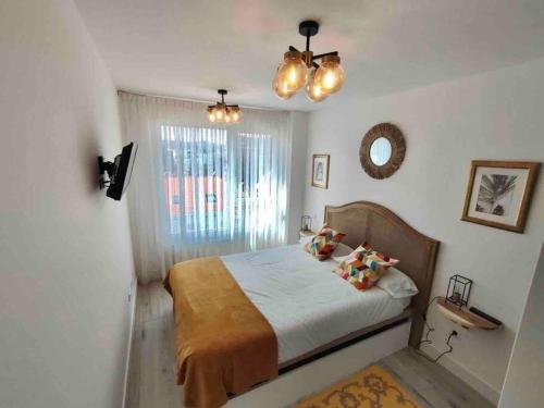 Schlafzimmer mit einem Bett, einem Fenster und Lichtern in der Unterkunft Exclusivo apartamento con aparcamiento gratuito in Laredo