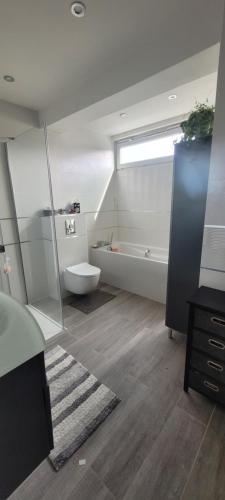 een badkamer met een bad, een wastafel en een toilet bij Maison Cosy in Franconville