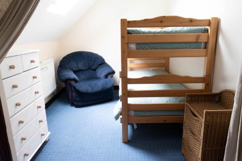 une chambre avec un lit superposé et une chaise dans l'établissement Le jardin des oiseaux – Escapade nature, à Saint-Georges-de-Reintembault