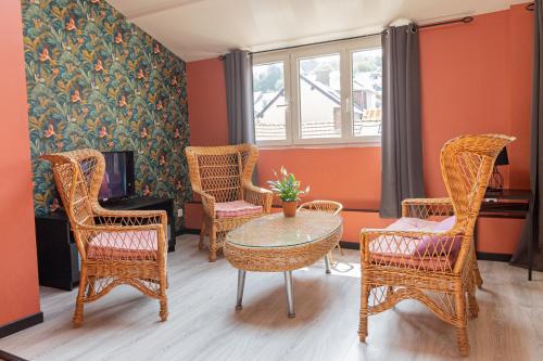 uma sala de estar com cadeiras de vime e uma mesa em La maison d'Yport em Yport