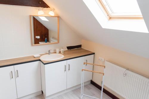 une salle de bain avec un lavabo et un miroir dans l'établissement Le jardin des oiseaux – Escapade nature, à Saint-Georges-de-Reintembault