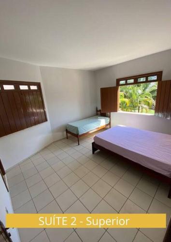 1 dormitorio con cama y ventana en Casa com vista mar. Um paraíso próximo à praia! en Ilhéus